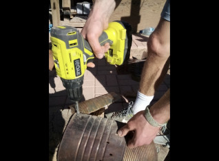 Liam drilling the cans for the heat riser insulation